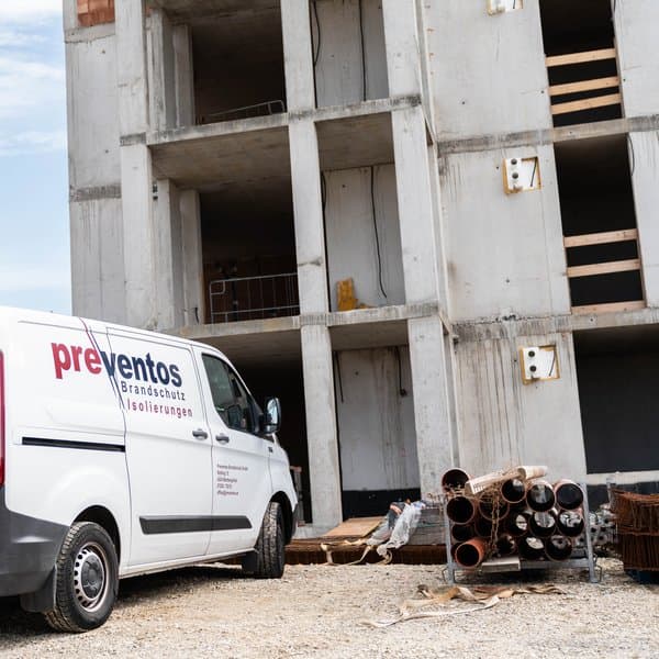 Firmenwagen von Preventos vor einem Rohbau