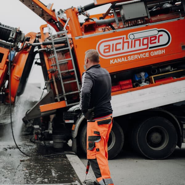 Mitarbeiter von Aichinger Kanalservice am Saug- und Spülwagen