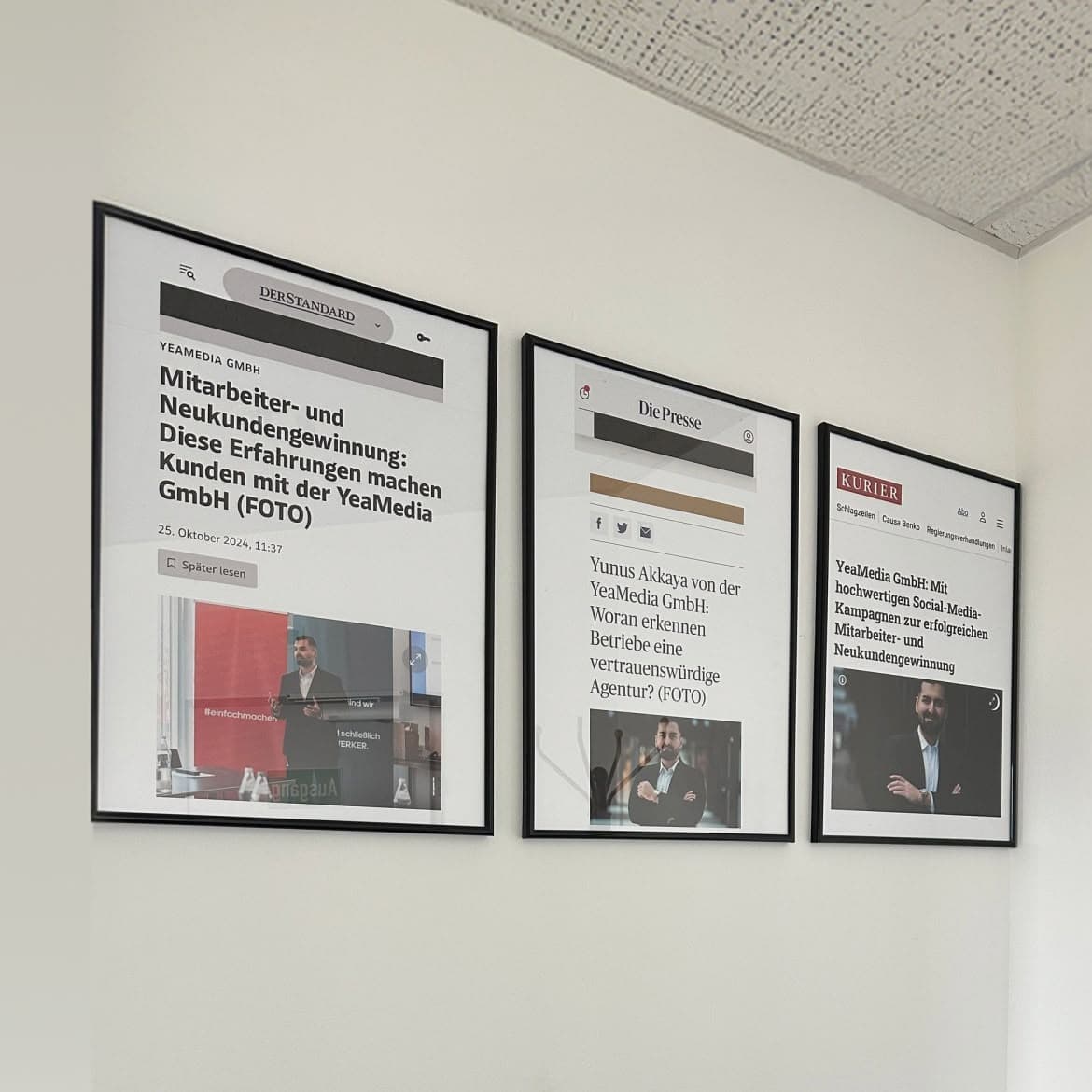 Gerahmte Presseberichte über die YeaMedia GmbH an einer Bürowand