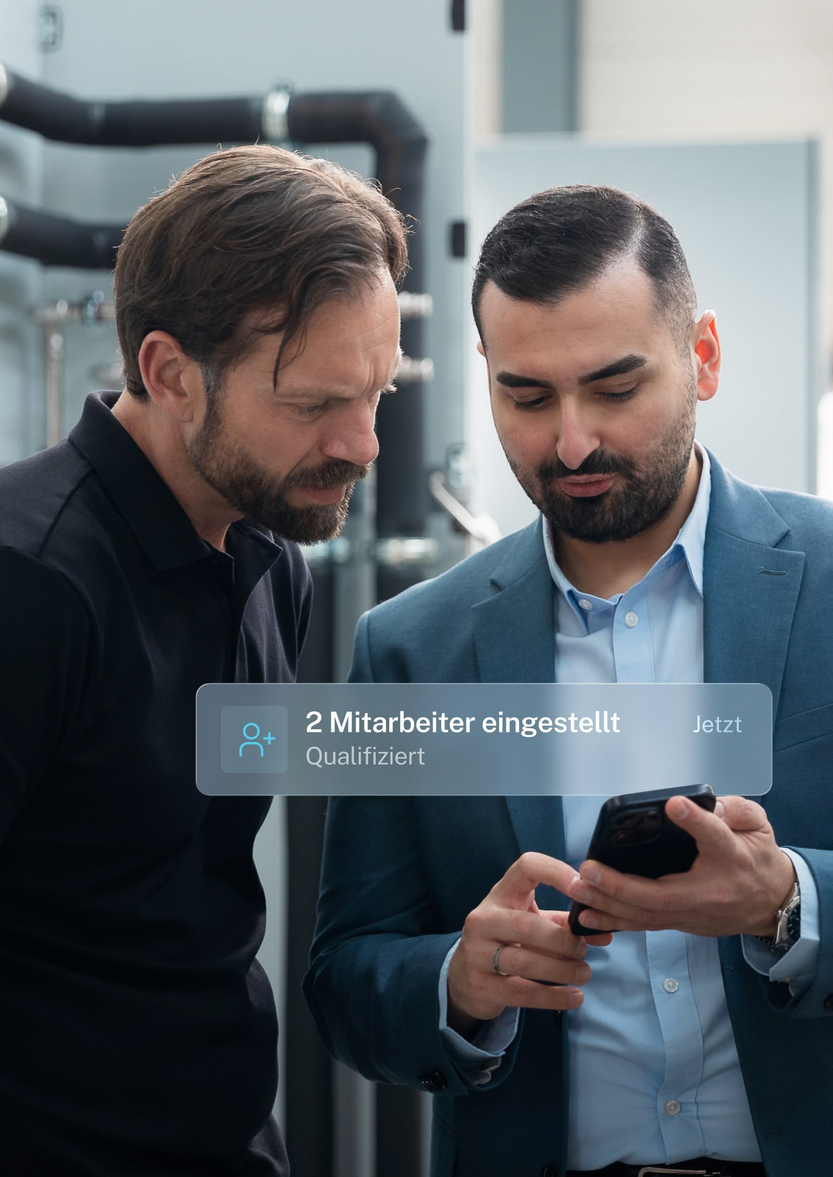 Betriebsleiter und YeaMedia-Berater sehen am Smartphone die Meldung: 2 Mitarbeiter eingestellt